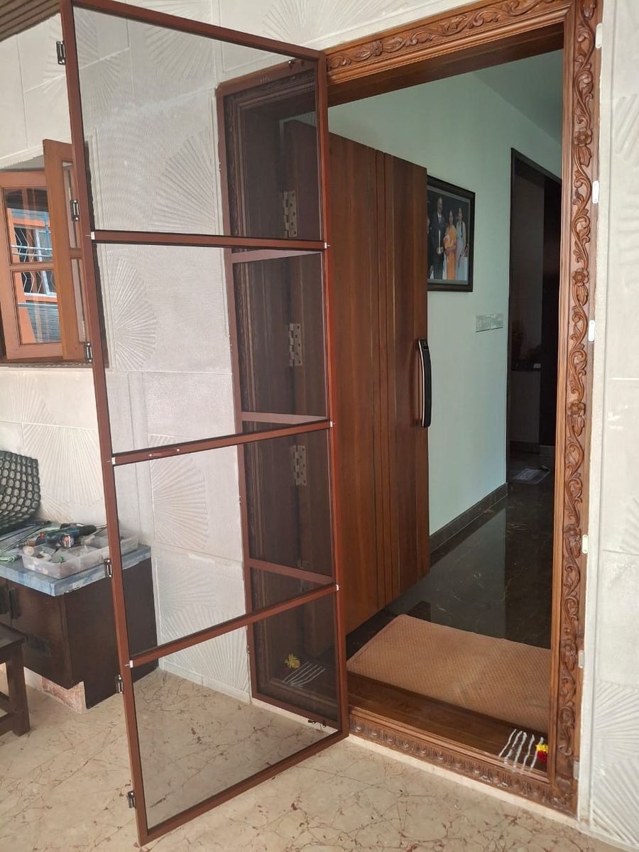 Mesh door opened inside a carved wooden door frame