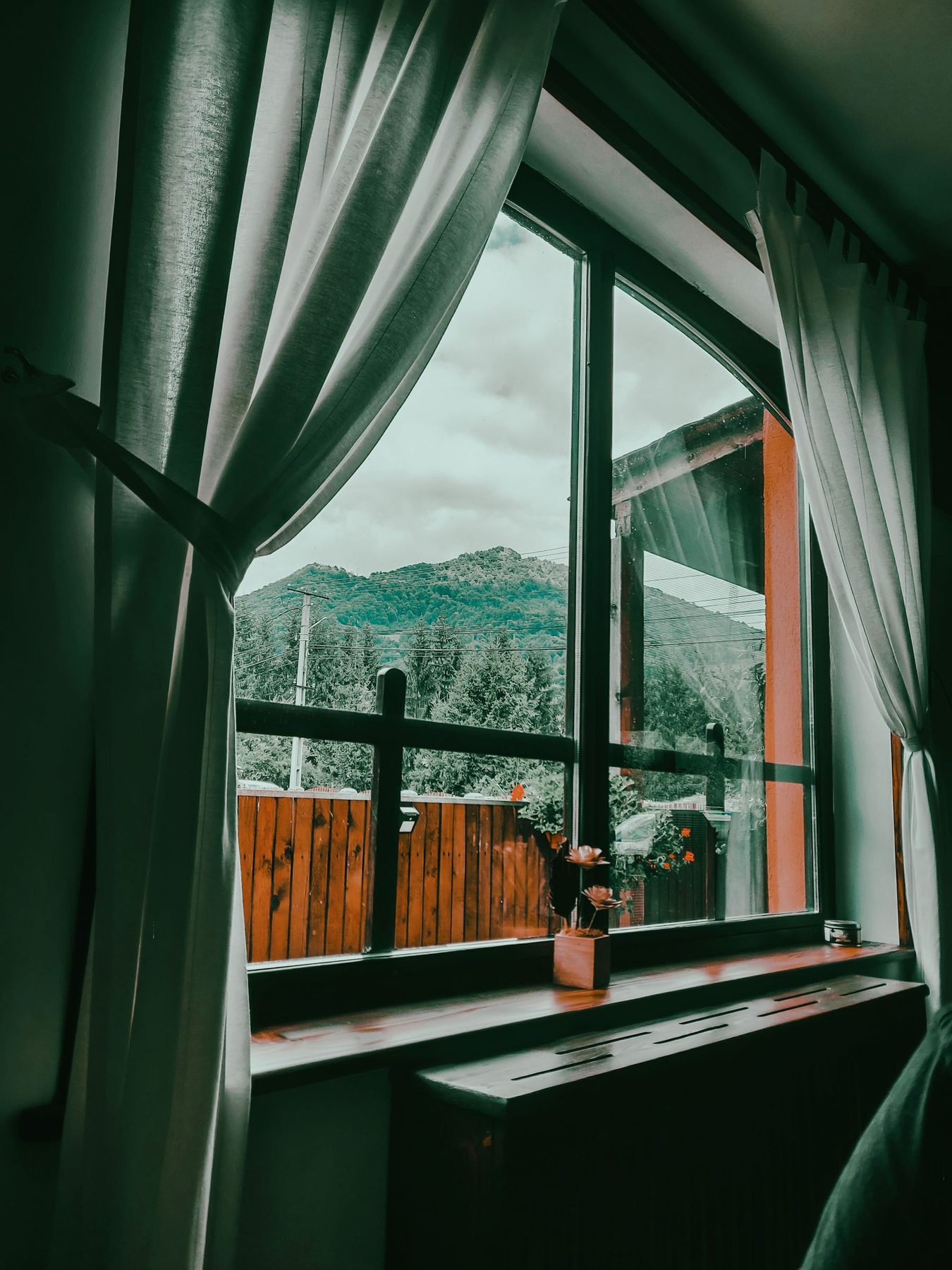 Window opening onto an autumn forested mountainside