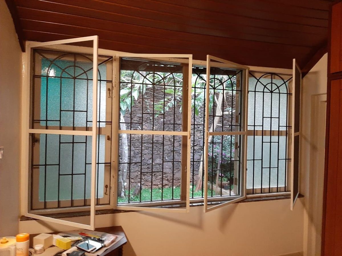 Openable mesh shutters on a row of grilled windows